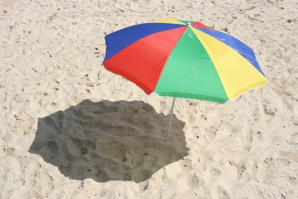 Солнечный зонтик на песке — стоковое фото