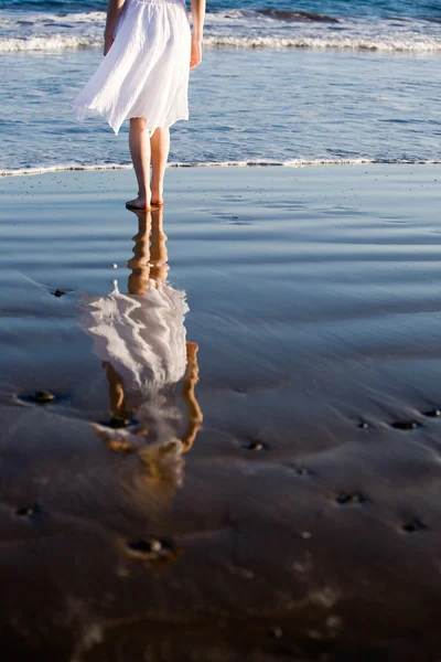 Kvinnen som går på stranda – stockfoto