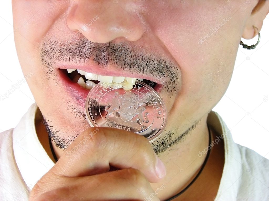 Closeup of man biting a coin to verify its authenticity on a whi