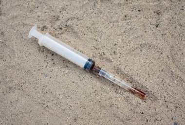 Syringe on the sand clipart