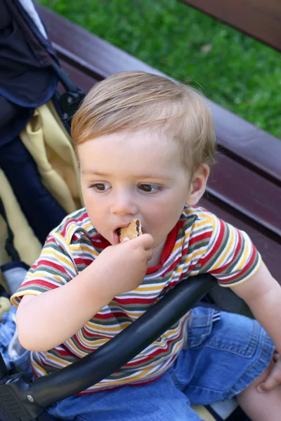 Walking boy eats biscuits — Stock Photo, Image