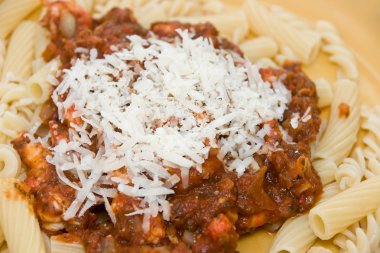 Pasta and tomatosauce with parmesan on top clipart