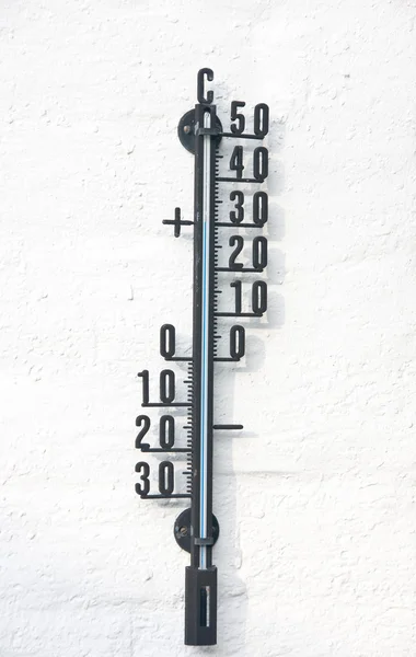 Thermometer in iron on a white wall — Stock Photo, Image