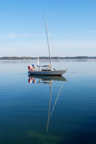 Ein Paar bereitet sein Segelboot im friedlichen See vor lizenzfreie Stockfotos