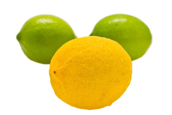 Gelbe und grüne Zitronen auf weißem Hintergrund — Stockfoto