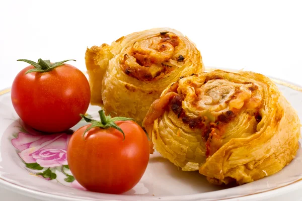 stock image Two pies and two tomatoes on a plate