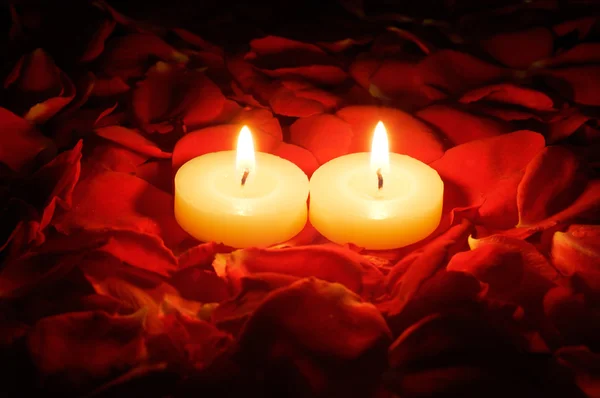 Свечи на лепестках роз — стоковое фото