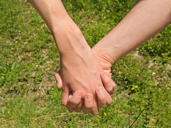 Two hands over green nature background. Love and friendship concept — Stock Photo, Image
