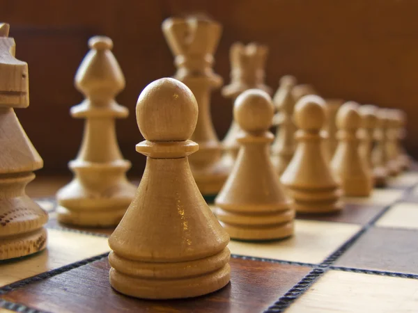 Деревянная бело-коричневая шахматная доска крупным планом — стоковое фото