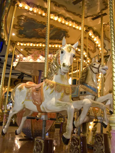 En gammaldags karusell på natten. detalj av två hästar — Stockfoto