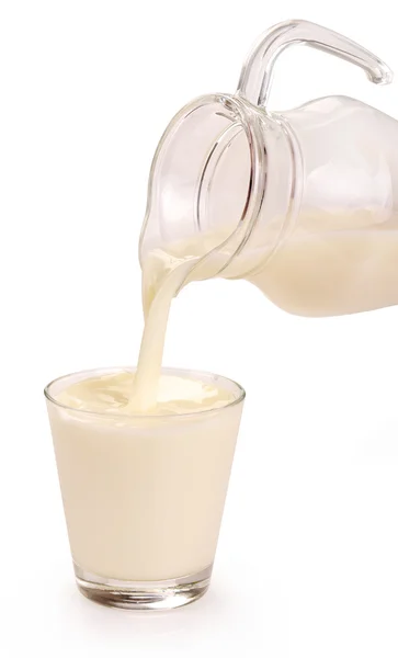Наливание молока в стакан — стоковое фото