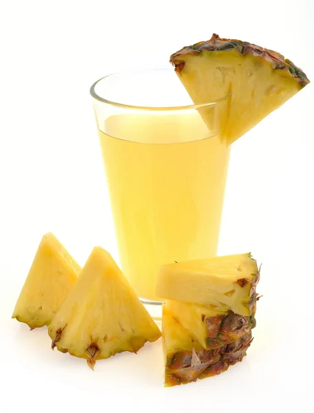 Sklenice ananasové šťávy a ananas plátky — Stock fotografie