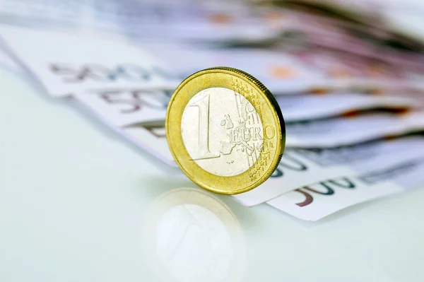 Ein-Euro-Münze auf 500-Euro-Banknoten — Stockfoto