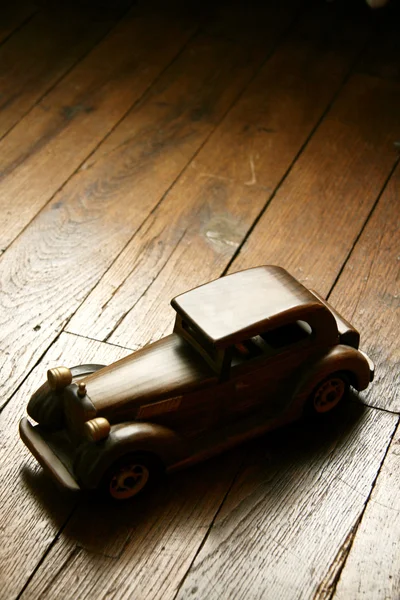 Retro trä bilmodell på parkettgolv Stockbild