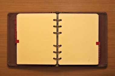 Leather bound journal on a wooden desk background clipart