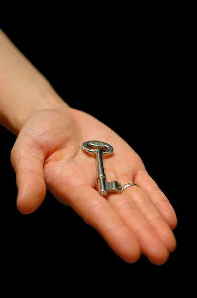 Main tendue tenant une clé de la maison — Photo