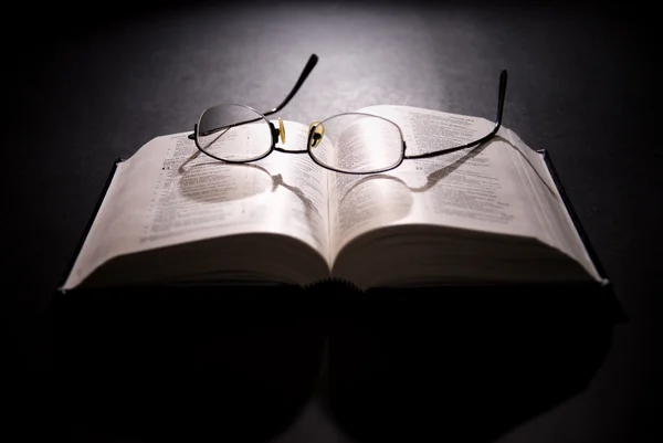 老眼鏡で開いた聖書 ロイヤリティフリーのストック写真