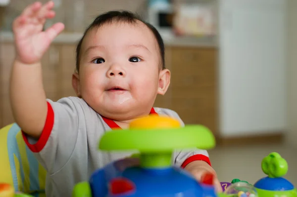 6 month old Asian baby girl plays sitting in a walker — Stock Photo, Image