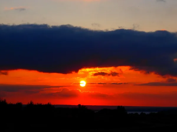 Coucher de soleil rouge vif avec un nuage sombre — Photo