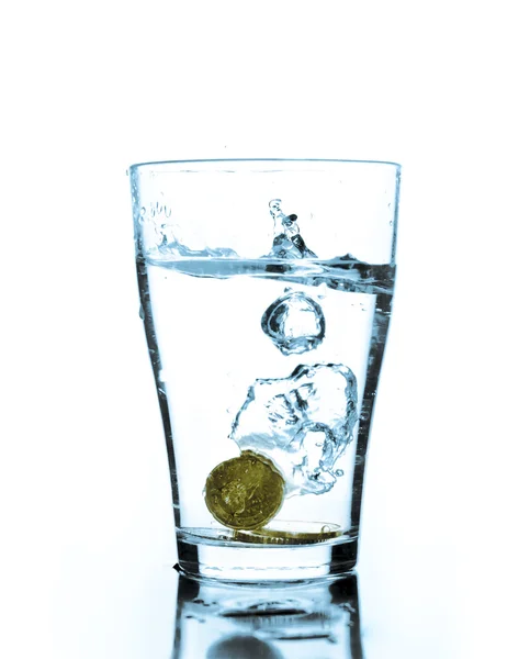 Splash of water and coins in a glass — Stock Photo, Image