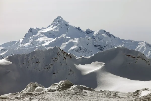 Βουνά στο χιόνι με ΣΥΝΝΕΦΙΑ — Φωτογραφία Αρχείου