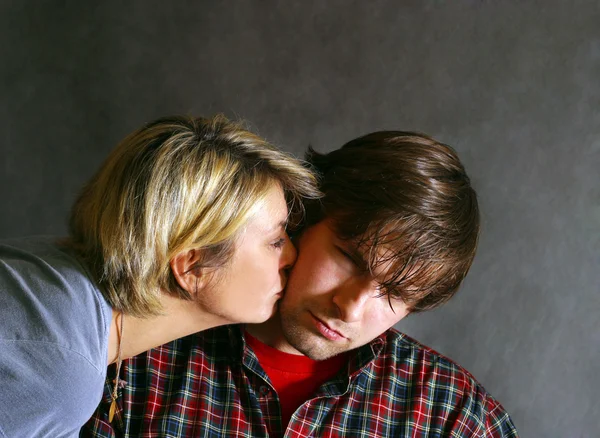 Женщина целует грустного мужчину — стоковое фото