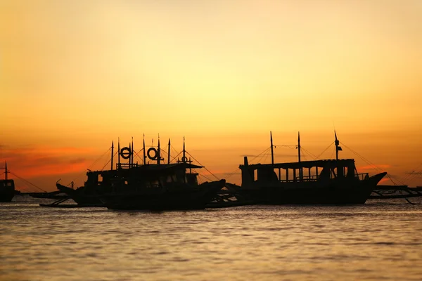 Günbatımında yüzen bir tekne — Stok fotoğraf