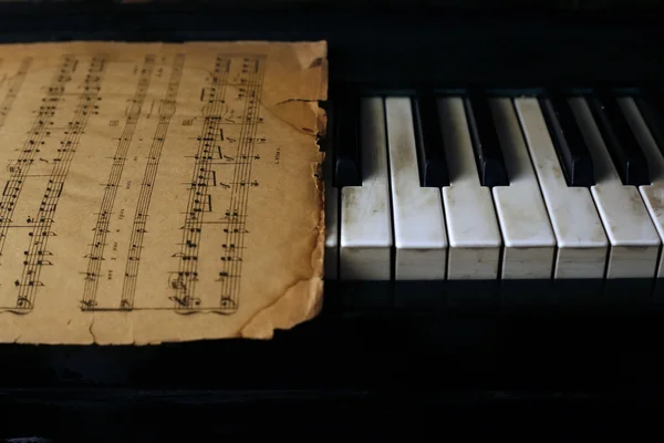 Клавиатура фортепиано и старые ноты — стоковое фото