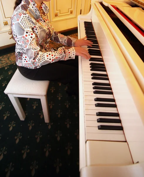 Kvinna som spelar vit piano — Stockfoto