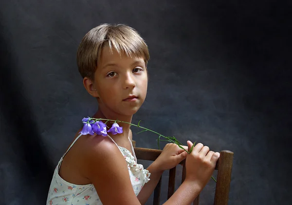 スタジオで青い花を持つ少女 — ストック写真