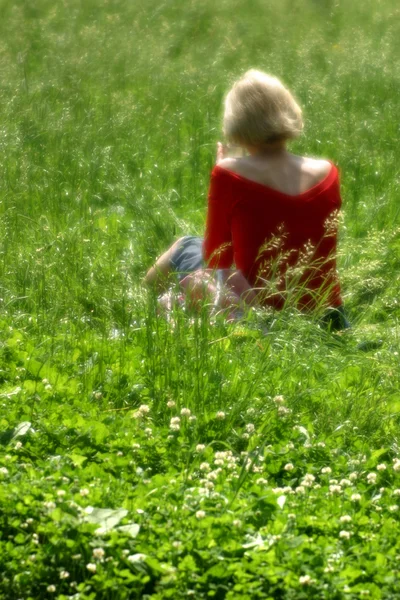 Женщина сидит на поляне — стоковое фото