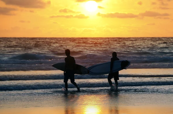 Surfers на заході сонця — стокове фото