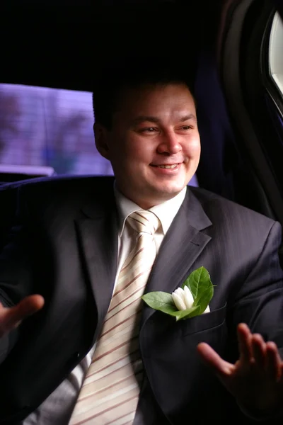 Vrolijk de bruidegom in auto — Stockfoto