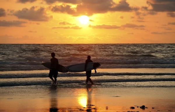 Surfers op sunset — Stockfoto