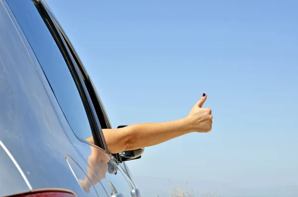 Молодая рука хорошо жестикулирует стеклом автомобиля. Символ того, что все хорошо — стоковое фото