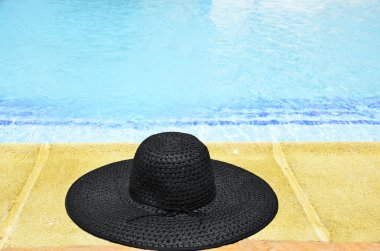 Woman's hat at the feet of the pool clipart