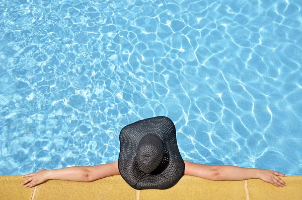 Жінки в розслабленому положенні в басейні з памелою — стокове фото