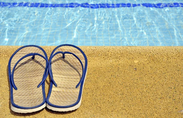 Sandálias femininas nos pés da piscina — Fotografia de Stock