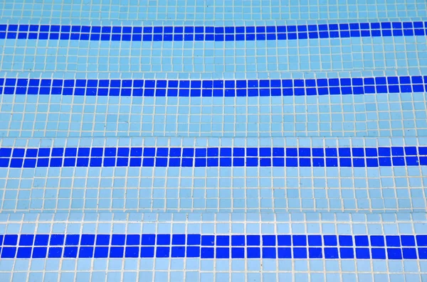 Escadas da telha na água azul da piscina — Fotografia de Stock