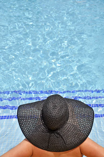 Donne con pamela in posizione rilassata in piscina — Foto Stock
