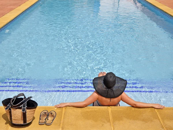 Frauen mit entspannter Pamela im Pool mit Tasche und Sandalen — Stockfoto