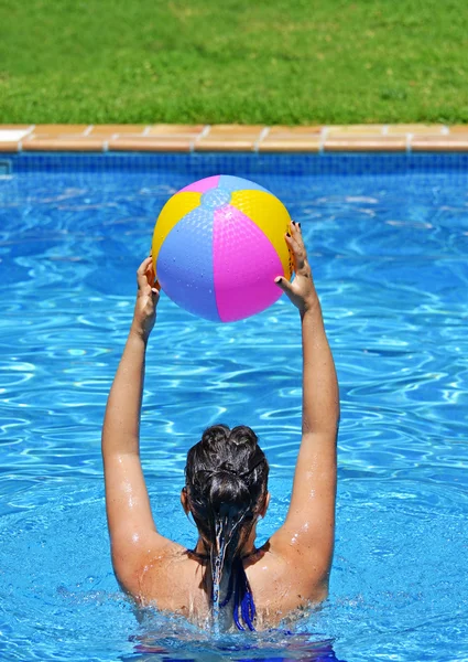 Mulher se exercitando na piscina com bola de praia — Fotografia de Stock