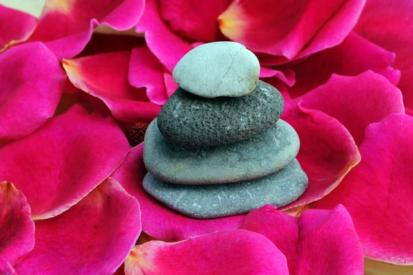 Zen stenen op rozenblaadjes — Stockfoto