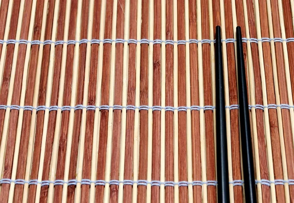 日本筷子竹餐垫背景上 — 图库照片