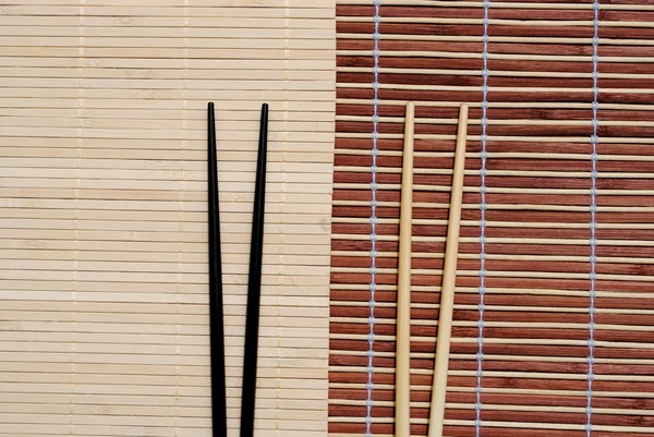 Japonês pauzinhos no fundo placemat bambu — Fotografia de Stock