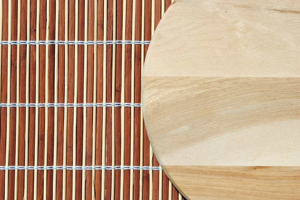Круглое деревянное блюдо высокого разрешения на бамбуковом фоне — стоковое фото
