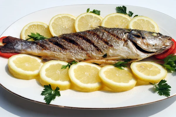Grill di pesce cotto con fette di limone — Foto Stock