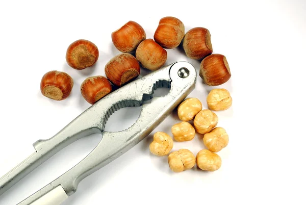 Hela och knäckt hasselnötter med nötknäppare — Stockfoto