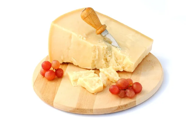 Italienischer Käse auf Holzbrett mit roten Trauben Stockbild