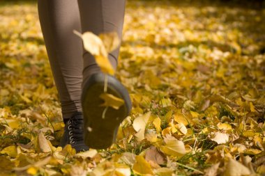 A lady is walking on green leaves